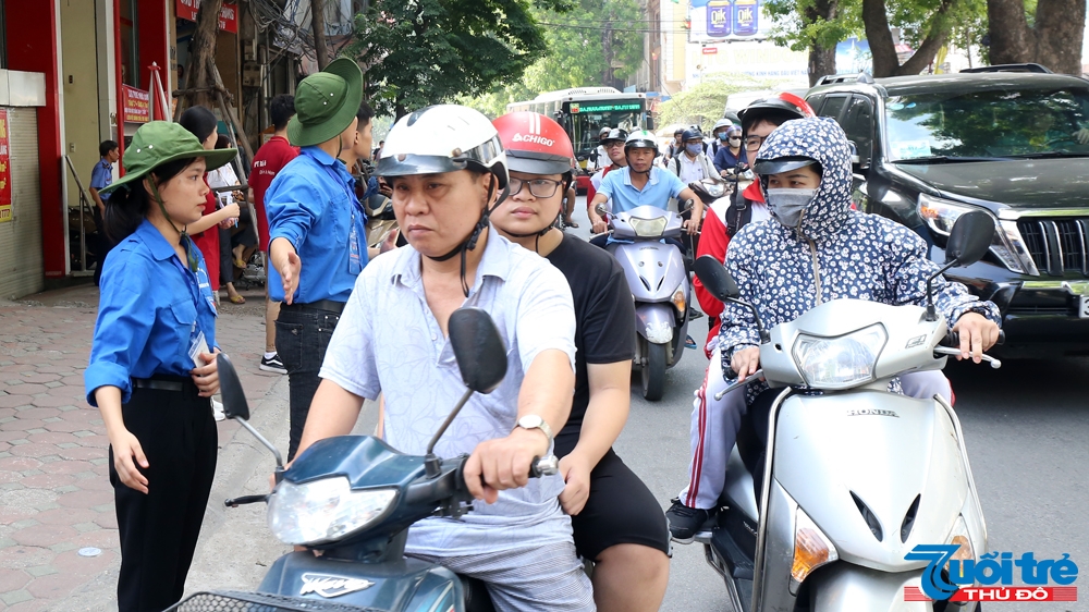 Thanh niên tình nguyện phân luồng giao thông trước cổng trường THPT Quang Trung, Hà Nội