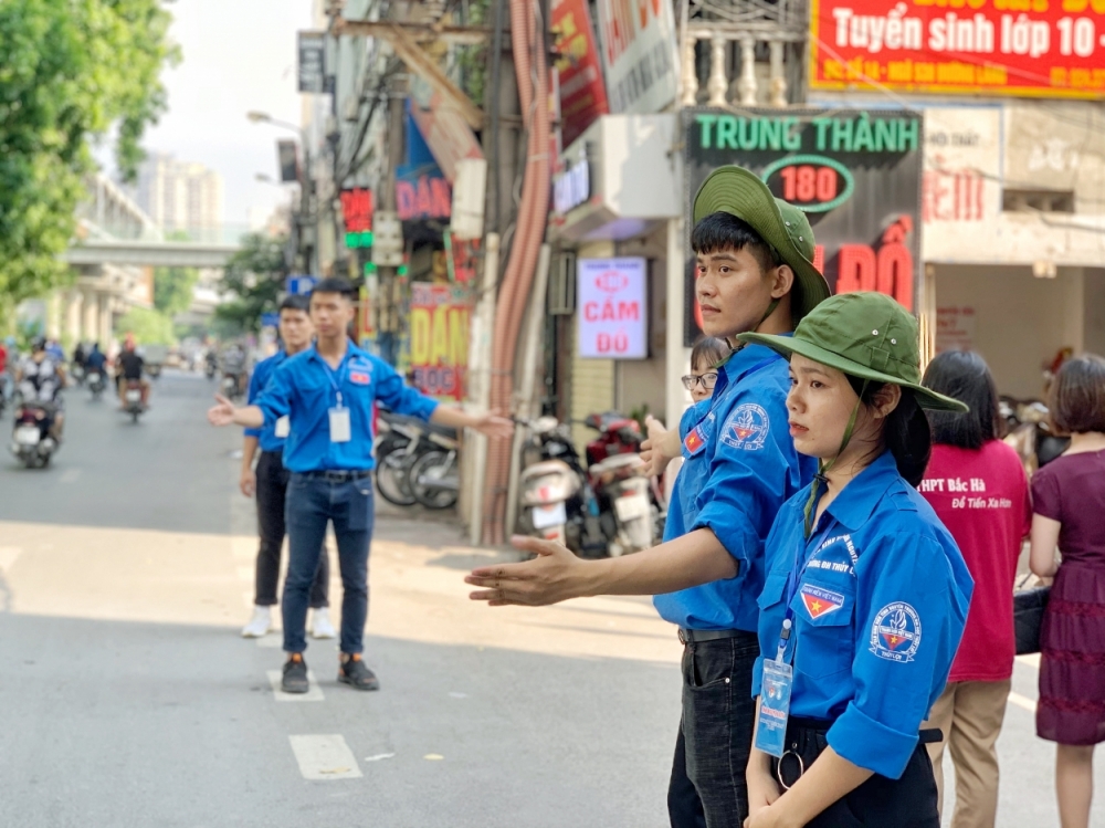 Tình nguyện viên hỗ trợ lực lượng chức năng điều tiết giao thông bên ngoài cổng trường THPT Quang Trung