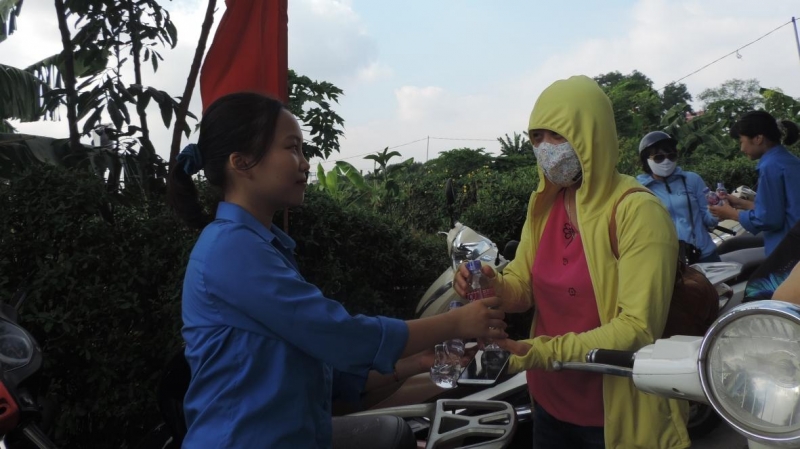 Tình nguyện viên quận Hoàng Mai trao tận tay người nhà thí sinh những chai nước mát