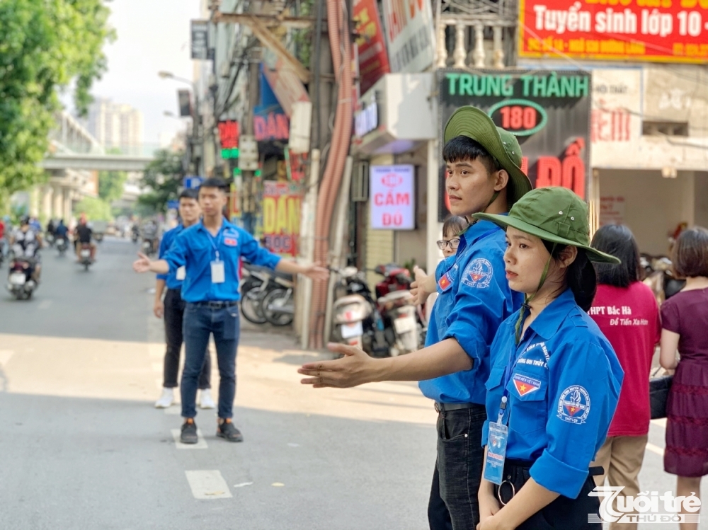 Tình nguyện viên hỗ trợ lực lượng chức năng điều tiết giao thông bên ngoài cổng trường THPT Quang Trung