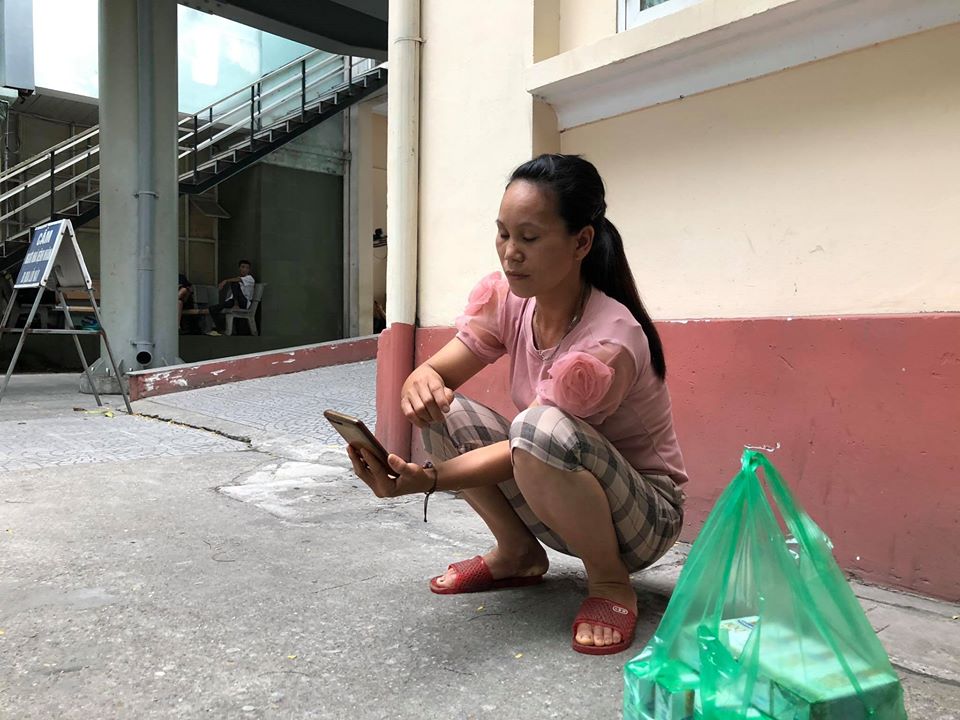 Chị Nguyễn Thị Phượng túc trực bên ngoài phòng bệnh mong chờ chồng tỉnh lại sau khi bị các đối tượng đâm trọng thương, rồi cướp chiếc xe máy