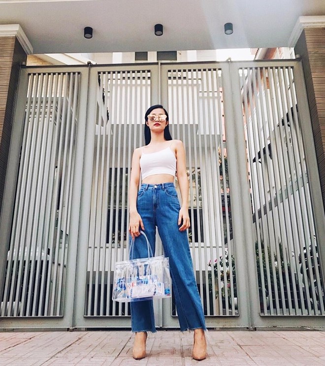 Với cặp đôi crop top và quần denim ống rộng, Đông Nhi đã khoe trọn vòng eo ''con kiến'' đáng ngưỡng mộ. Không những vậy, chủ nhân ca khúc ''Bad Boy'' còn bắt nhịp trào lưu phụ kiện trong suốt với chiếc túi tote nhựa đẹp mắt.