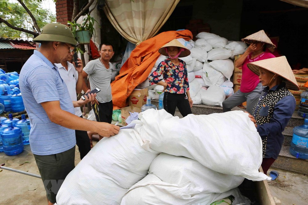 Người dân thôn Nhân Lý, xã Nam Phương Tiến đến nhận hàng cứu trợ tại các tổ trong thôn. (Ảnh: Thành Đạt/TTXVN)