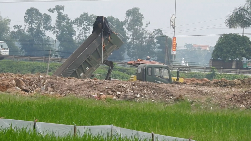 Những chiếc xe lấy đất từ mỏ của Công ty Cổ phần Khoáng sản Bắc Giang và đồ về dự án tại huyện Việt Yên.