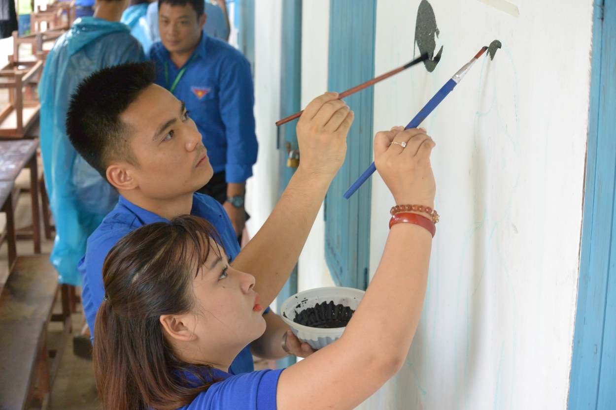 Đồng chí Lý Duy Xuân, Trưởng Ban Tuyên giáo Thành đoàn Hà Nội và Nguyễn Quỳnh Trang, Bí thư quận Đoàn Hoàng Mai, Hà Nội đang trang trí lại trường tiểu học napock bằng các bức tranh