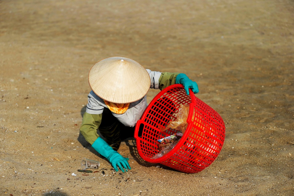 Những hạt nhãn, hạt mận hay mẩu đầu lọc thuốc lá rơi rải rác, vùi dưới cát khiến các chị phải tỉ mỉ nhặt từng thứ một.