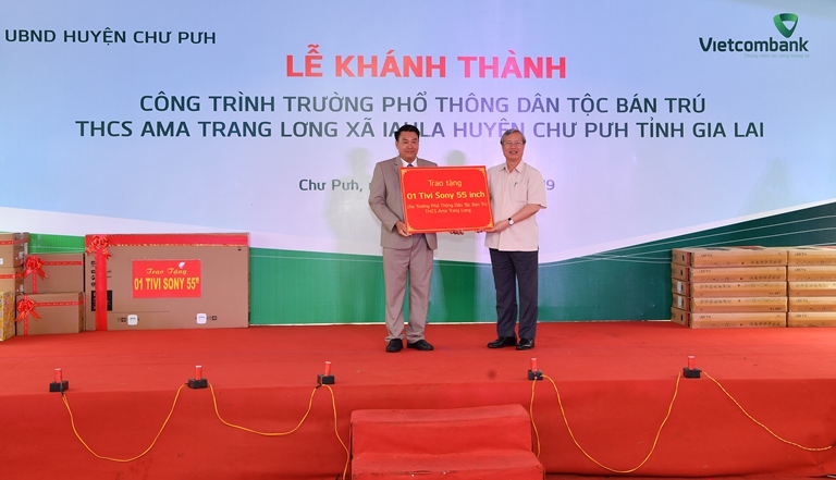 Đ/c Trần Quốc Vượng - Ủy viên Bộ Chính trị, Thường trực Ban Bí thư TƯ Đảng (bên phải) trao tặng quà cho thầy và trò Trường PTDT Bán trú A Ma Trang Lơng