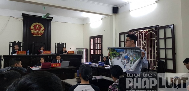 Bị cáo Nguyễn Bá Cường dùng hình ảnh chứng minh bản thân bị lực lượng công an đè, bẻ tay tại phiên tòa ngày 29/11/2018