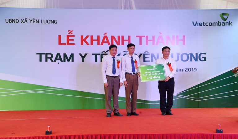 Phó Tổng Giám đốc Vietcombank Đào Minh Tuấn (bên phải) trao tượng trưng số tiền 2 tỷ đồng tài trợ xây dựng Trạm y tế