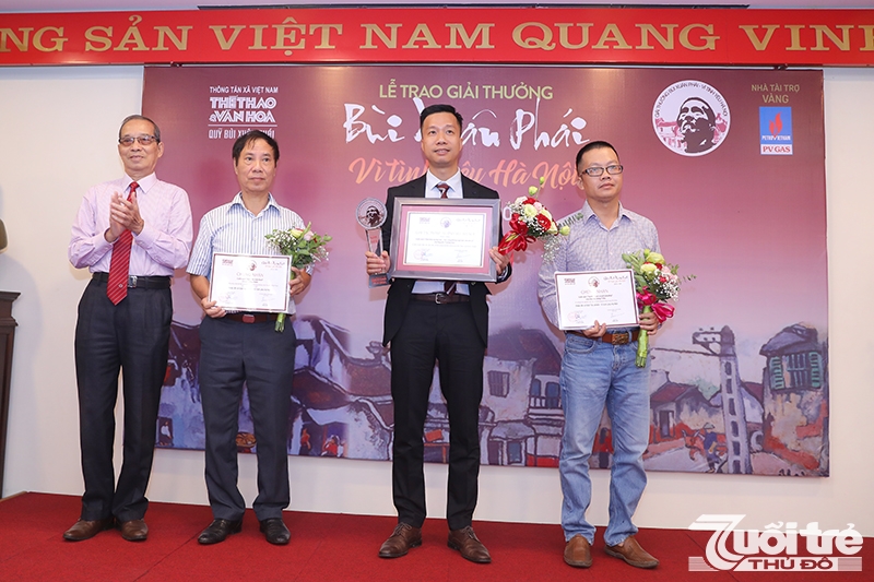 Nhà thơ Bằng Việt, Chủ tịch Hội đồng Giám khảo trao tặng giải Tác phẩm- Vì Tình yêu Hà Nội cho nhà văn Nguyễn Trương Quý (giữa) và giấy chứng nhận cho hai đề cử