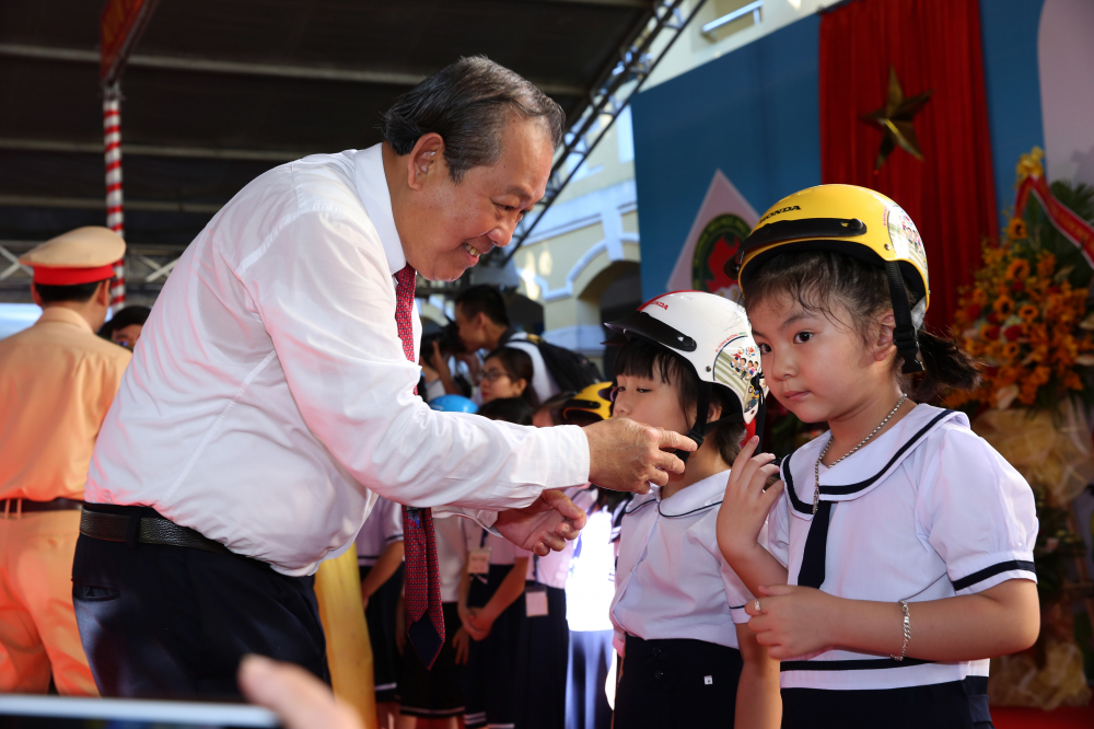 Phó Thủ tướng Thường trực Trương Hòa Bình tặng mũ bảo hiểm cho các em học sinh lớp 1.