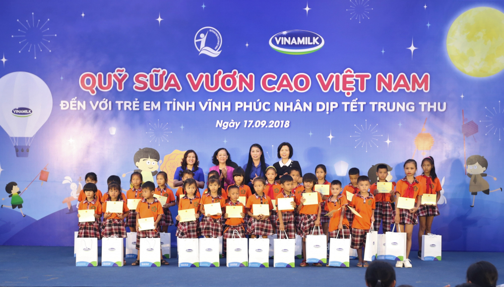 Bà Trương Thị Mai - Uỷ viên Bộ chính trị, Bí thư Trung ương Đảng, Trưởng ban Dân vận Trung ương; bà Nguyễn Thị Hà - Thứ trưởng Bộ Lao động - Thương Binh và Xã hội; bà Hoàng Thị Thuý Lan - Bí thư Tỉnh uỷ Vĩnh Phúc và bà Bùi Thị Hương - Giám đốc Điều hành Vinamilk trao quà và sữa cho các em học sinh