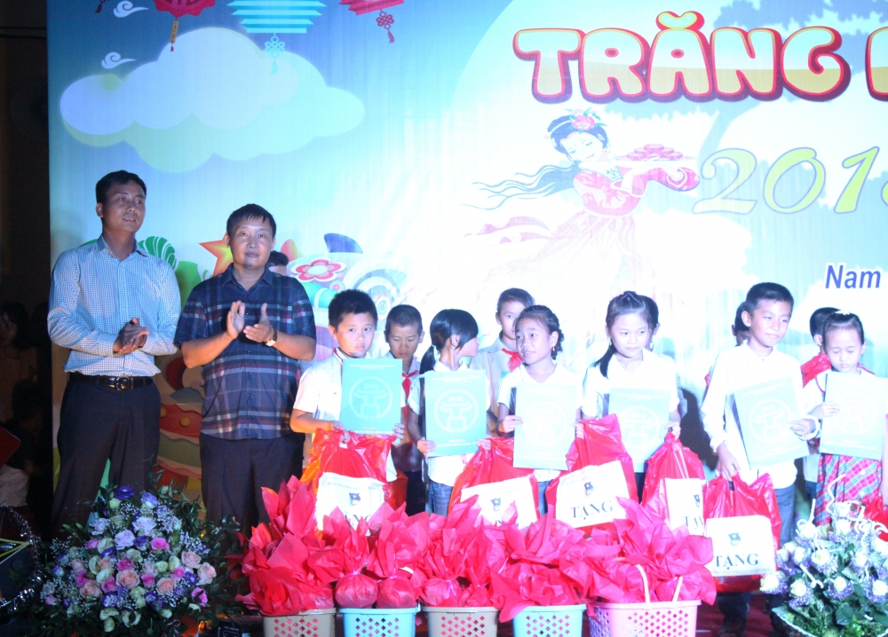 Đồng chí Nguyễn Đức Tiến, Phó bí thư Thành đoàn Hà Nội (người đầu tiên, bên trái) trao quà tới các bạn nhỏ