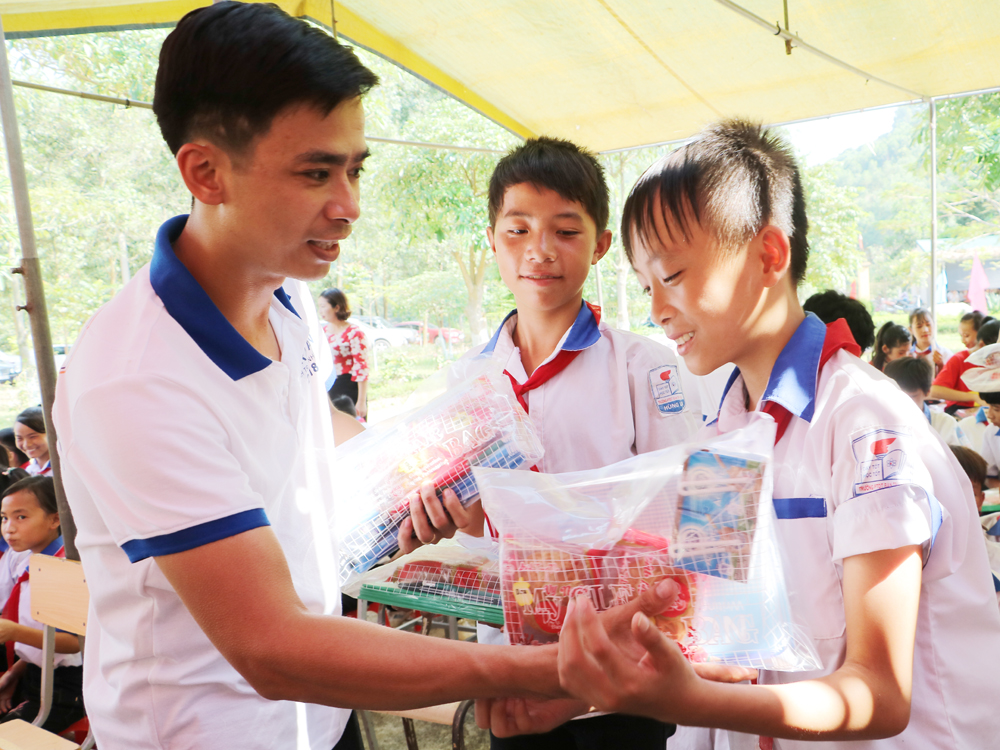 Đồng chí Nguyễn Hữu Thọ, Phó Giám đốc Công ty Cổ phần  Ô tô Đại Nam trao quà tới các em học sinh