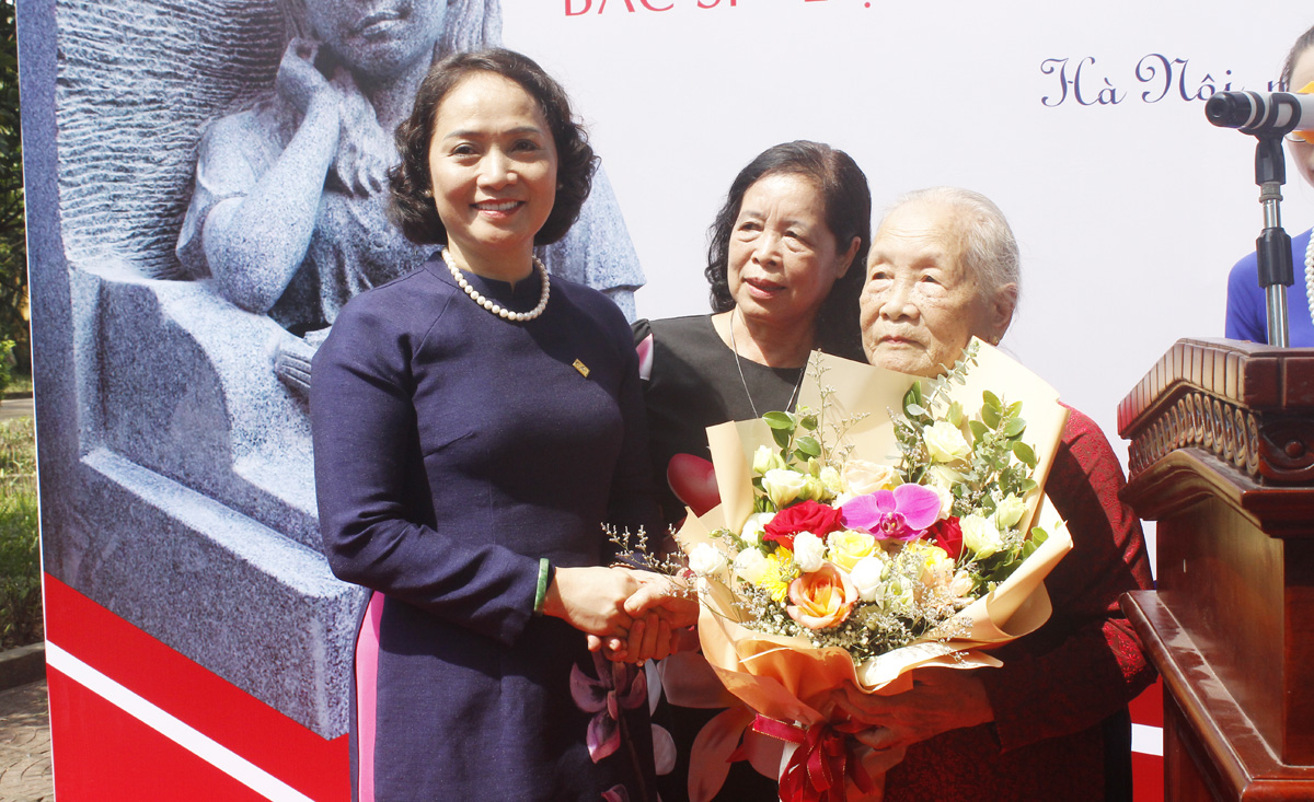 Cô Lê Mai Anh - Hiệu trưởng trường THPT Chu Văn An tặng hoa mẹ liệt sĩ Đặng Thùy Trâm