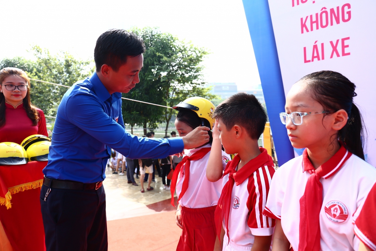 Đại diện lãnh đạo Trung ương Đoàn và Thành đoàn Ha Nội trao mũ bảo hiểm tới các bạn thiếu nhi