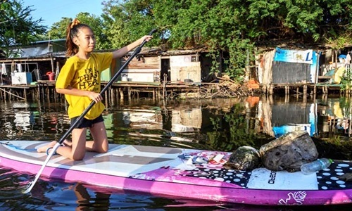 Lliy đang thu gom rác trên một con kênh tại thủ đô Bangkok.