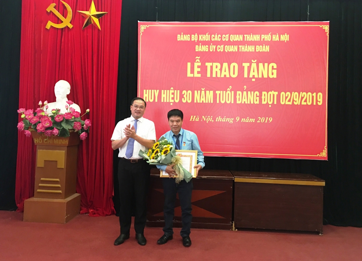 Đồng chí Nguyễn Ngọc Việt, UVBTV Trung ương Đoàn, Bí thư Đảng ủy, Bí thư Thành đoàn, Chủ tịch Hội Liên hiệp Thanh niên Việt Nam Thành phố Hà Nội trao Huyb hiệu 30 tuổi Đảng tới đồng chí Phạm Nghĩa
