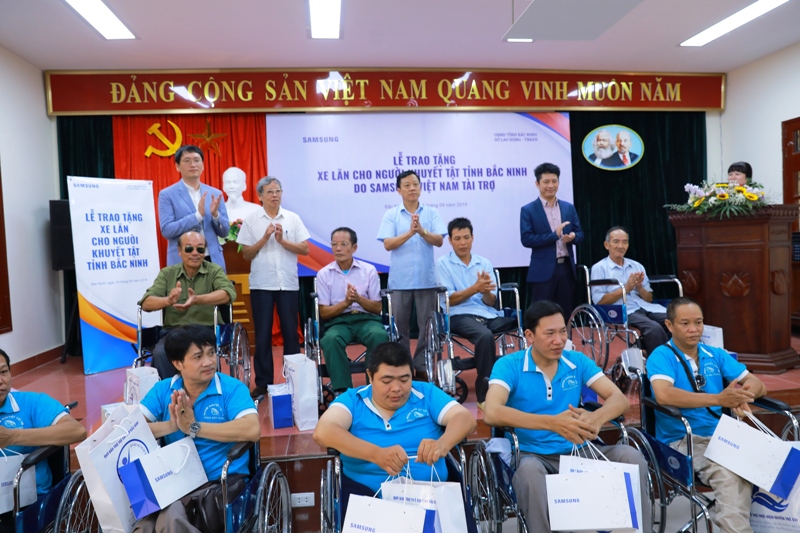 Đại diện Ban tổ chức trao xe lăn tới người khuyết tật