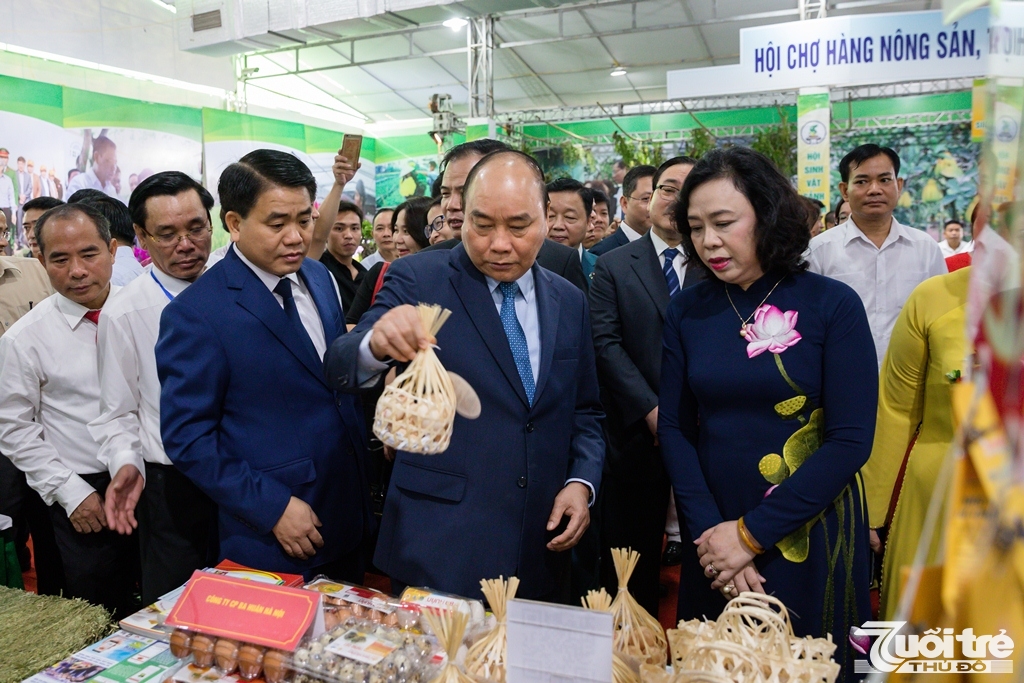 Đồng chí Nguyễn Xuân Phúc, Ủy viên Bộ Chính trị, Thủ Tướng Chính phủ cùng các đại biểu tham quan các gian hàng tại Hội chợ hàng nông sản, thủ công mỹ nghệ và sản phẩm OCOP Thủ đô