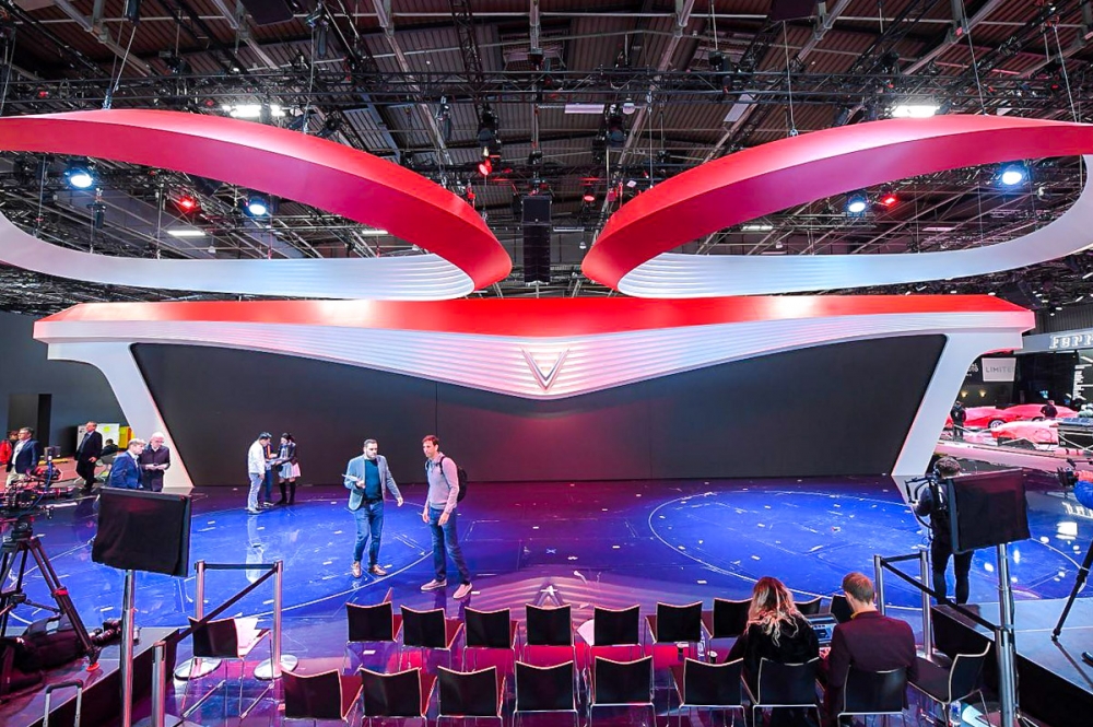 Sân khấu ra mắt VinFast tại Paris Motorshow, với logo hình chữ V nằm chính giữa, hai cánh trải ra hai bên mô phỏng đèn xe “mắt hi” của VinFast. Viền đỏ chạy dài tại phần sải cánh của màn hình đem lại cảm giá mới mẻ, tràn đầy năng lượng.