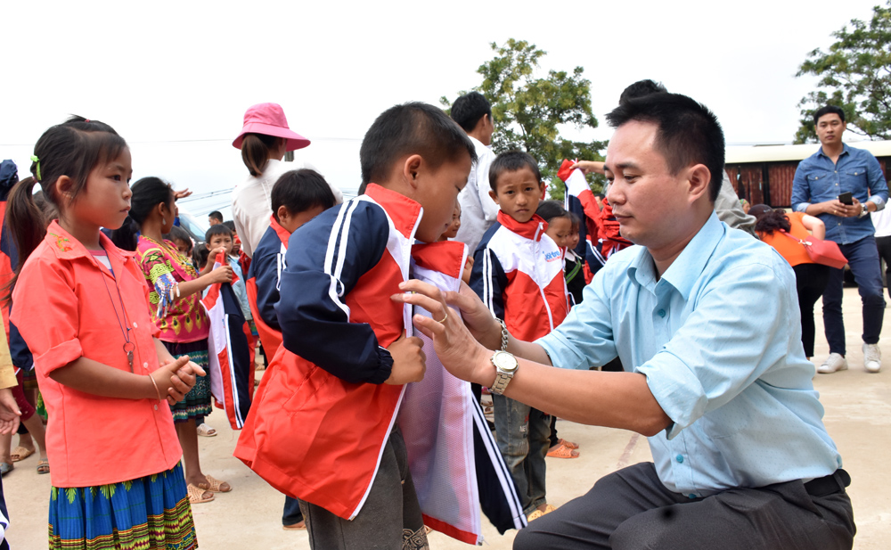 Đồng chí Ngô Vương Tuấn, Phó bí thư Chi bộ, Phó Tổng biên tập báo Tuổi trẻ Thủ đô tặng áo cho các em học sinh