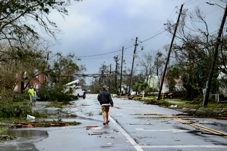 Một người đàn ông đi bộ trên đường ở thành phố Panama, bang Florida sau cơn bão