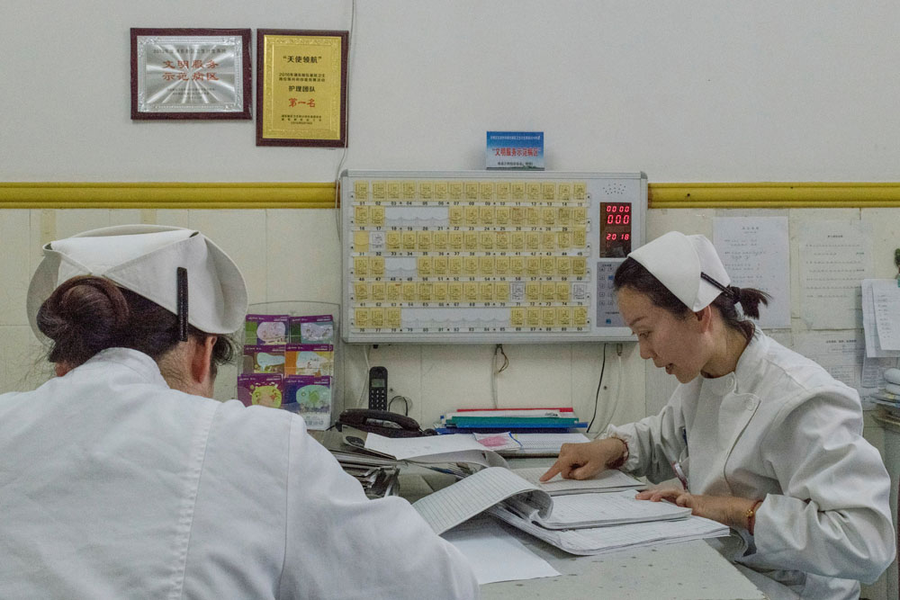 Các y tá xem danh sách bệnh nhân tại Trung tâm Dịch vụ Y tế Cộng đồng Gaoqiao ở Thượng Hải (Ảnh: The New York Times)