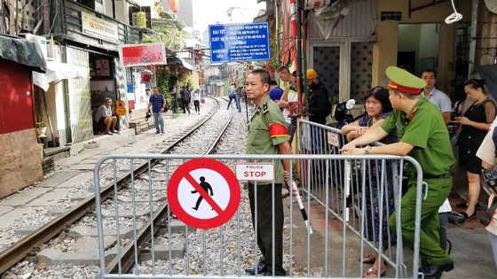 Lực lượng chức năng dùng barie phong tỏa lối vào khu vực đường sắt có nhiều quán cà phê ở Hà Nội