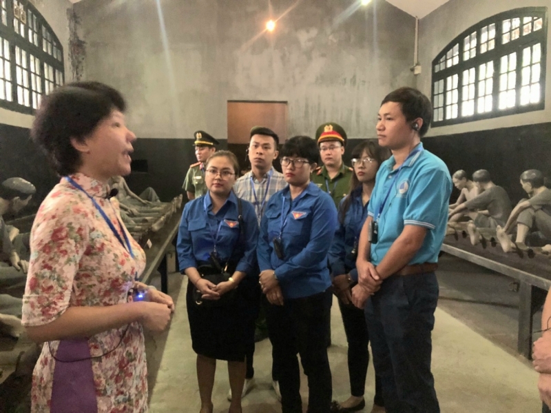 Các đại biểu Đoàn khối công nhân viên chức quận Hoàng Mai nghe thuyết minh tại di tích Nhà tù Hỏa Lò