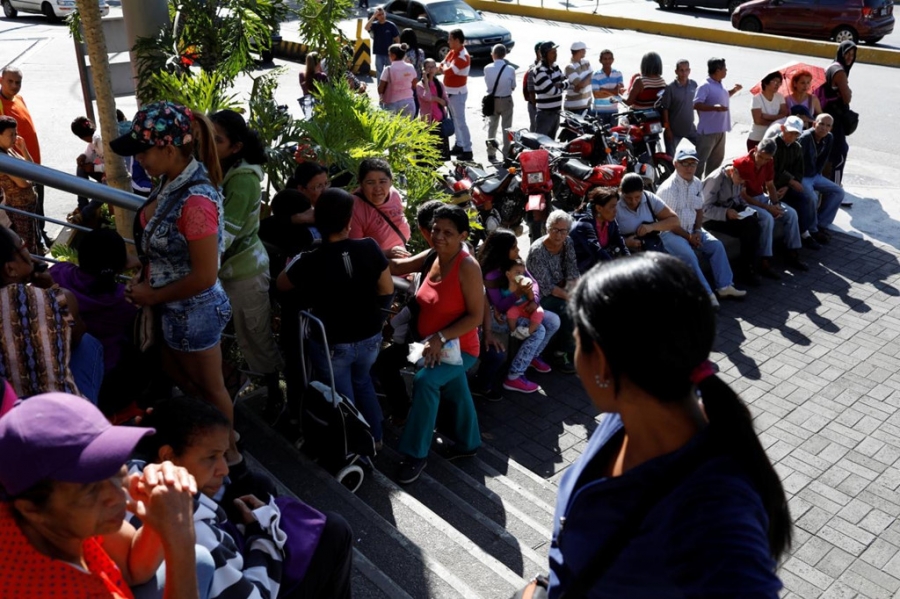 Người Venezuela đang xếp hàng chờ mua thực phẩm trước một siêu thị tại thủ đô Caracas. Ảnh: Reuters