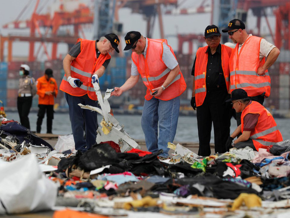 Nhân viên Ủy ban An toàn Giao thông Quốc gia Indonesia kiểm tra các mảnh vỡ tìm thấy sau vụ tai nạn rơi máy bay của hãng hàng không Lion Air (Ảnh: Reuters)