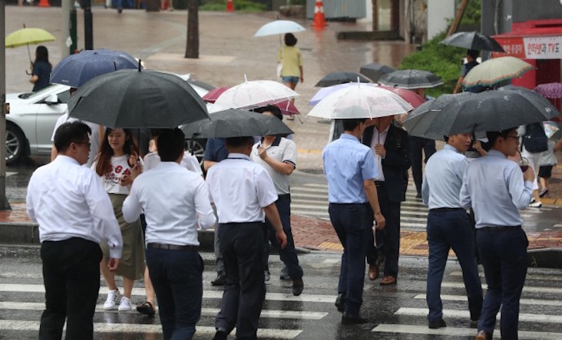 Nhân viên văn phòng tại Hàn Quốc đang vội vã di chuyển trên một con phố tại thủ đô Seoul. Ảnh: Yonhap.
