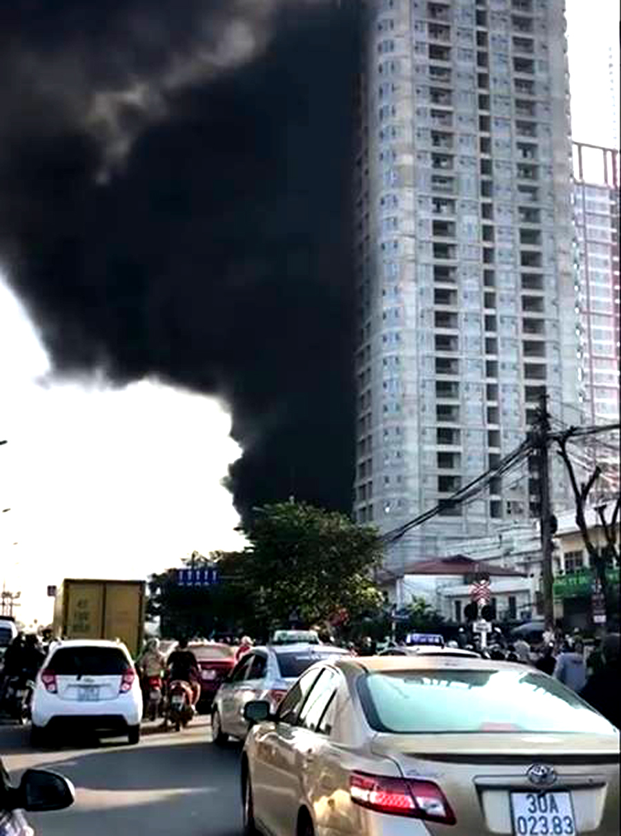 Cột khói đen bốc lên từ một chung cư cao tầng khiến nhiều người đi đường hoảng sợ