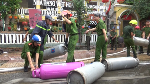 Các chiến sĩ đưa bình ga khỏi nơi hỏa hoạn tránh nổ lan truyền