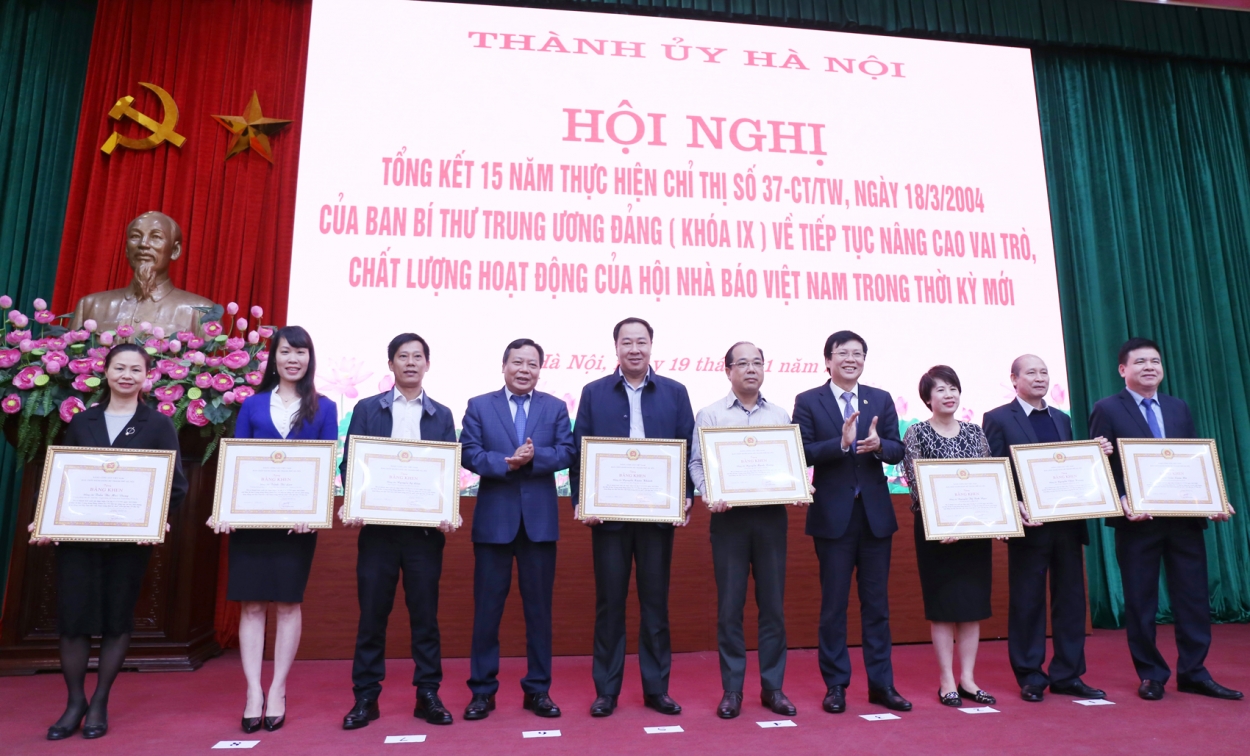 Phó Chủ tịch Thường trực Hội Nhà báo Việt Nam Hồ Quang Lợi và Trưởng Ban Tuyên giáo Thành ủy Nguyễn Văn Phong trao bằng khen cho các cá nhân có thành tích xuất sắc trong thực hiện Chỉ thị 37-CT/TW.