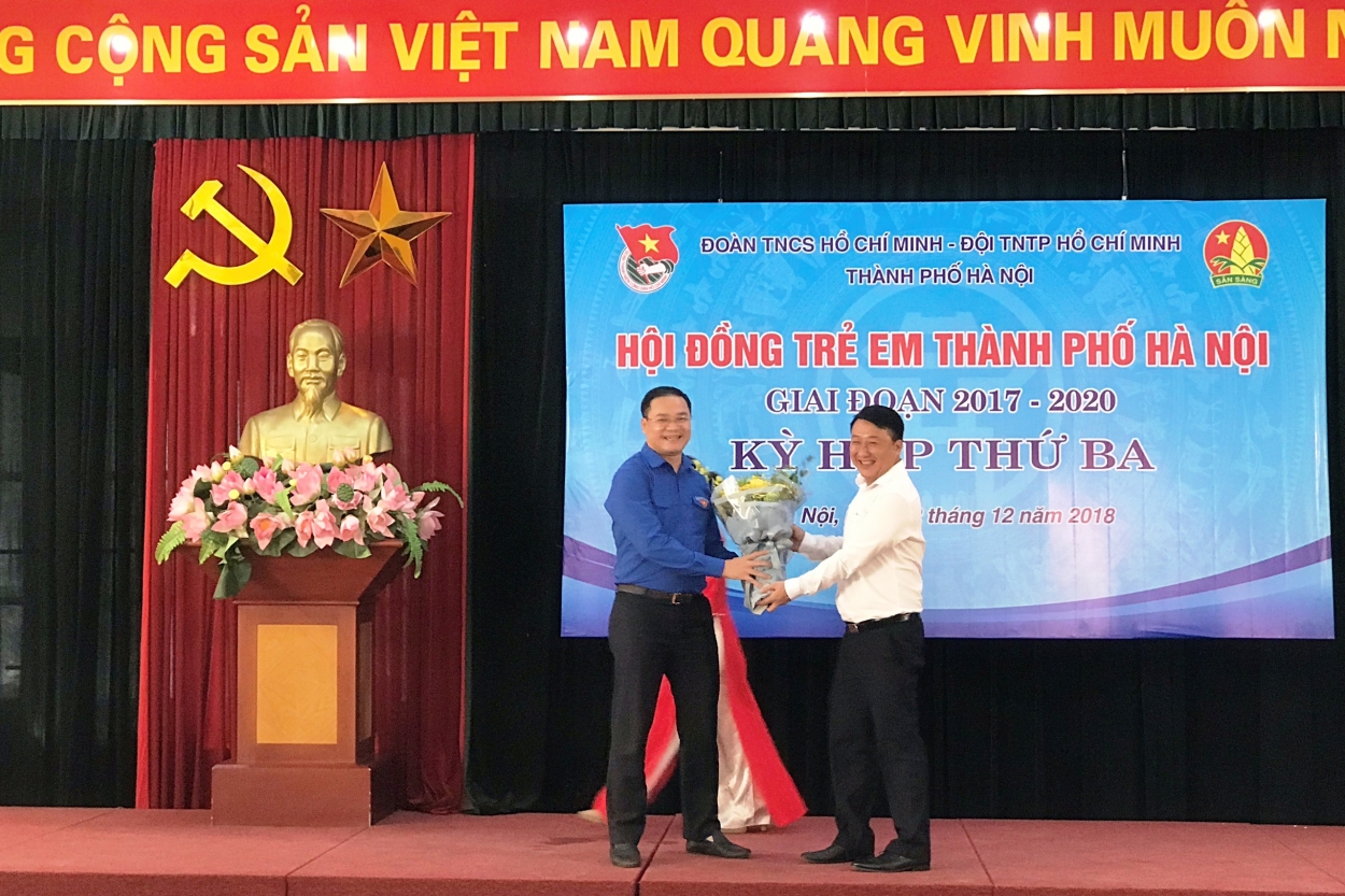 Đồng chí Nguyễn Khánh Bình - UVBCH Trung ương Đoàn, Phó Bí thư Thường trực Thành đoàn, Chủ tịch Hội đồng Đội thành phố Hà Nội (áo trắng) tặng hoa chúc mừng đồng chí Nguyễn Ngọc Việt, Bí thư Thành đoàn, Chủ tịch Hội LHTN Việt Nam TP Hà Nội được kiện toàn là Trưởng Ban Tham vấn của Hội đồng trẻ em TP.