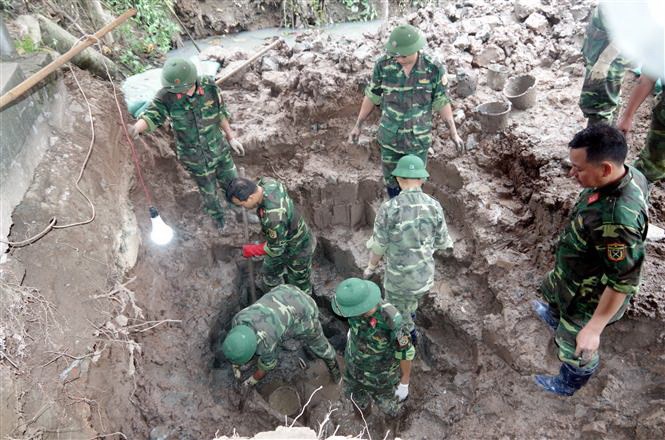 Lực lượng công binh đang tìm kiếm số bom bi sót lại. (Ảnh: TTXVN phát)