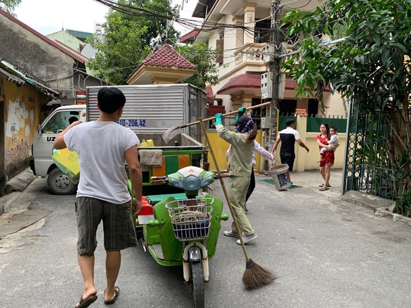 Chị Thảo nhanh nhẹn dùng xẻng nhồi những túi rác vào trong thùng xe