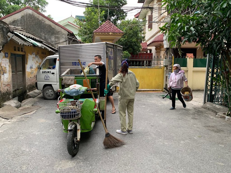 Người dân tổ 13 phường Phúc Lợi đem rác ra bỏ vào xe lôi điện