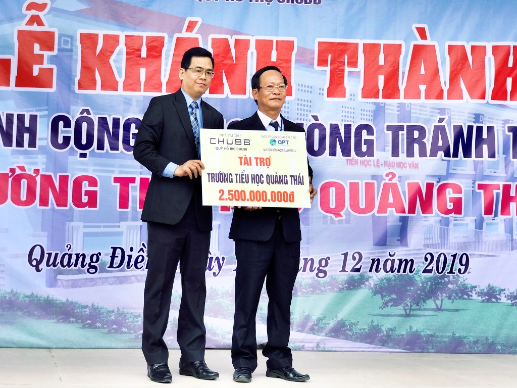 Ông Bùi Thanh Hiệp, Phó Tổng Giám đốc Chubb Life Việt Nam (bên trái) trao tài trợ cho đại biểu trường Tiểu học Quảng Thái