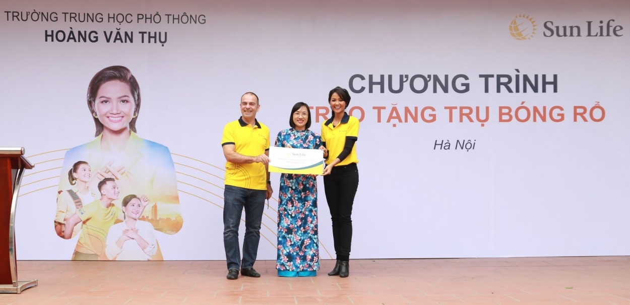 Ông Larry Madge - Tổng Giám đốc Sun Life Việt Nam và Hoa hậu H'Hen Niê trao biểu trưng trụ bóng rổ cho trường trung học phổ thông Hoàng Văn Thụ, Hà Nội