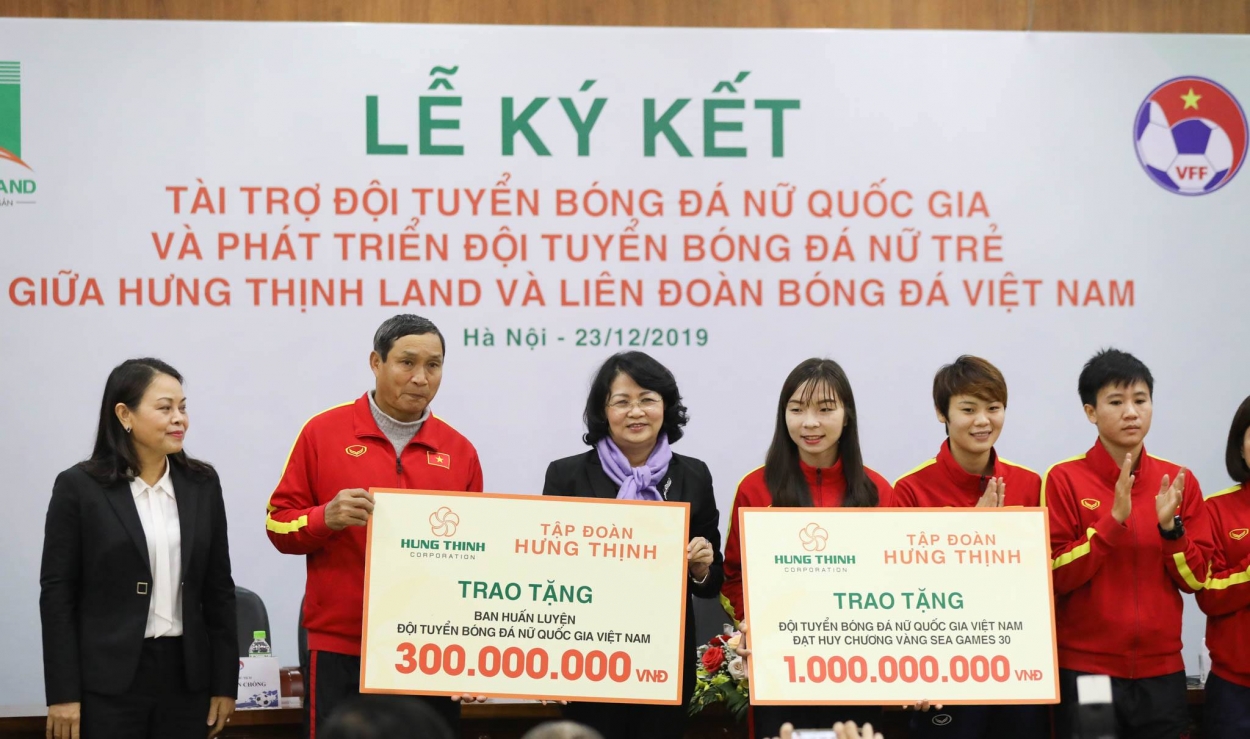 Bà Đặng Thị Ngọc Thịnh - Phó Chủ tịch nước và bà Nguyễn Thị Thu Hà - Uỷ viên Trung ương Đảng, Chủ tịch Hội Liên hiệp Phụ nữ Việt Nam (ngoài cùng bên trái) cùng các đại diện của Tập đoàn Hưng Thịnh và VFF trao tặng 1 tỷ đồng tiền thưởng cho Đội tuyển bóng đá nữ Việt Nam và 300 triệu đồng cho Ban huấn luyện đội tuyển bóng đá nữ