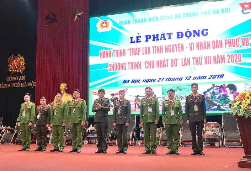 Đại tá Hoàng Văn Hùng, Đảng ủy viên, Chánh Văn phòng Đảng ủy Công an thành phố Hà Nội trao thẻ tình nguyện tới đại diện các đơn vị thuộc Đoàn Thanh niên Công an Thủ đô