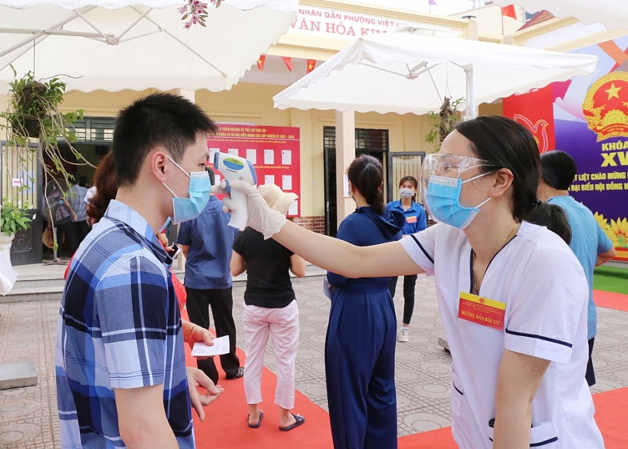 Cử tri được cán bộ y tế đo thân nhiệt, sát khuẩn tay và thực hiện khuyến cáo 5K trước khi vào khu vực bầu cử