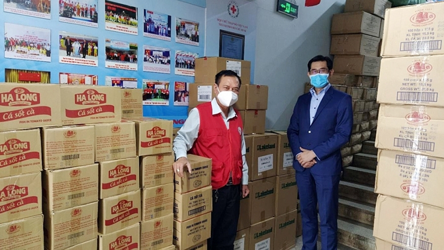 Ông Harry Loh, Tổng Giám đốc, Ngân hàng UOB Việt Nam (phải), và ông Trần Trường Sơn, Chủ tịch Hội Chữ thập đỏ Thành phố Hồ Chí Minh (trái) cùng với số lượng đồ hộp và vật tư y tế sẵn sàng để phân phối
