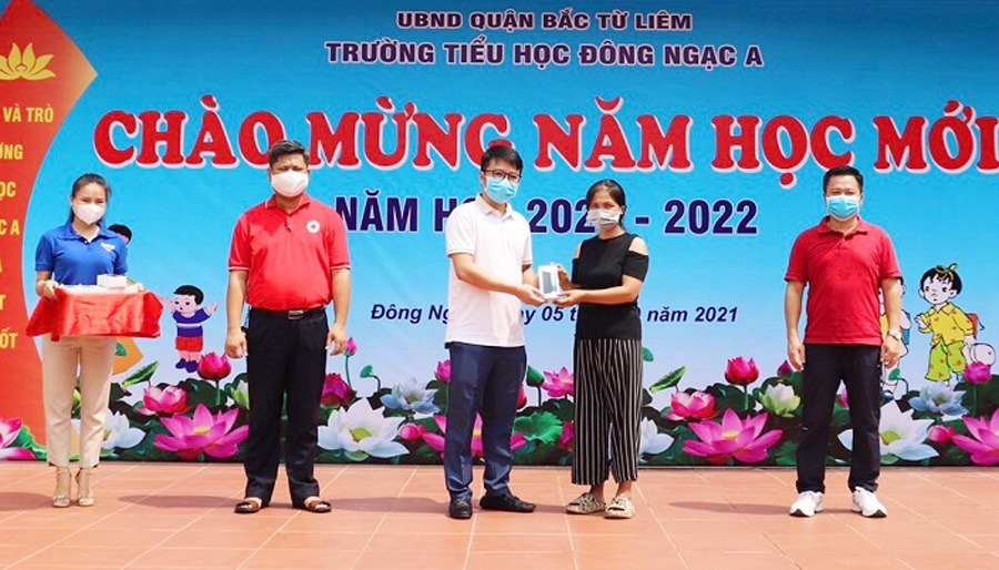 Cha mẹ HS có hoàn cảnh khó khăn thay mặt con nhận quà từ BGH trường Tiểu học Đông Ngạc A