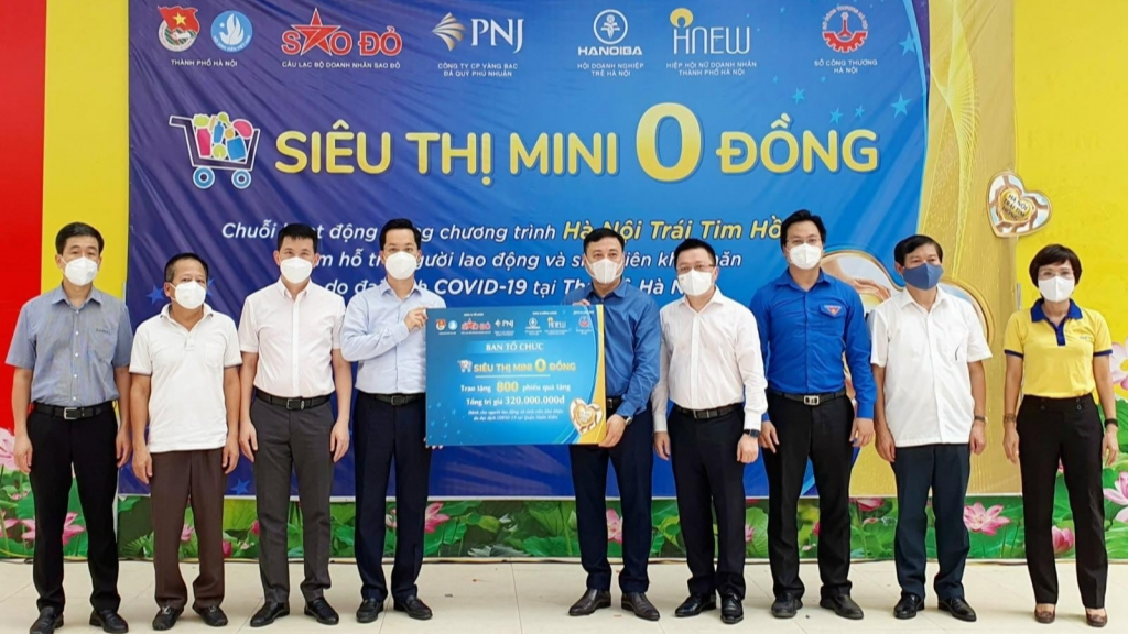 Đại diện Ban Tổ chức “Siêu thị mini 0 đồng” trao 800 phiếu mua hàng tặng đại diện chính quyền quận Hoàn Kiếm.