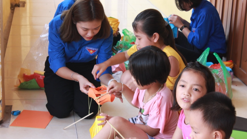 Tình nguyện viên cùng các em học sinh làm đèn lồng