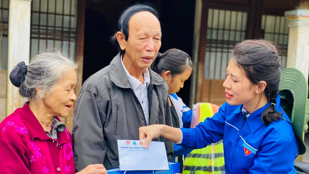 chị Hoàng Thị Huyền Trang, Bí thư Quận đoàn, Chủ tịch Hội đồng Đội quận Hà Đông trao quà tới người dân bị ảnh hưởng bởi bão lũ 